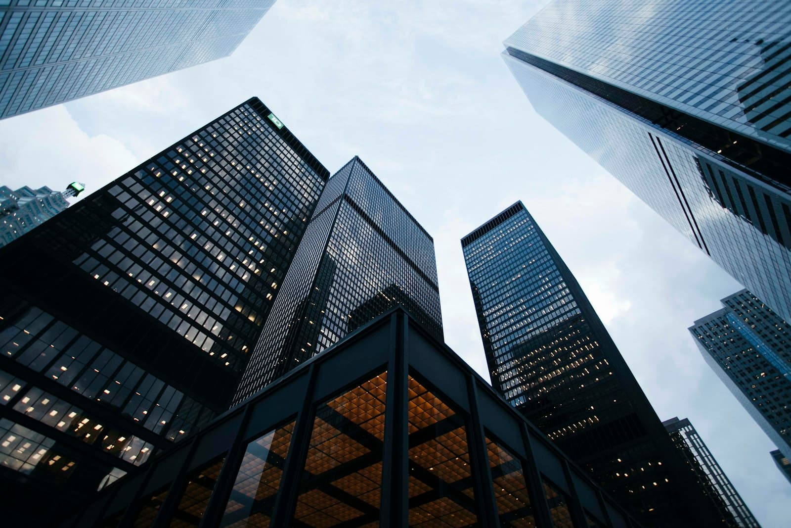 Modern glass buildings against a pale blue sky